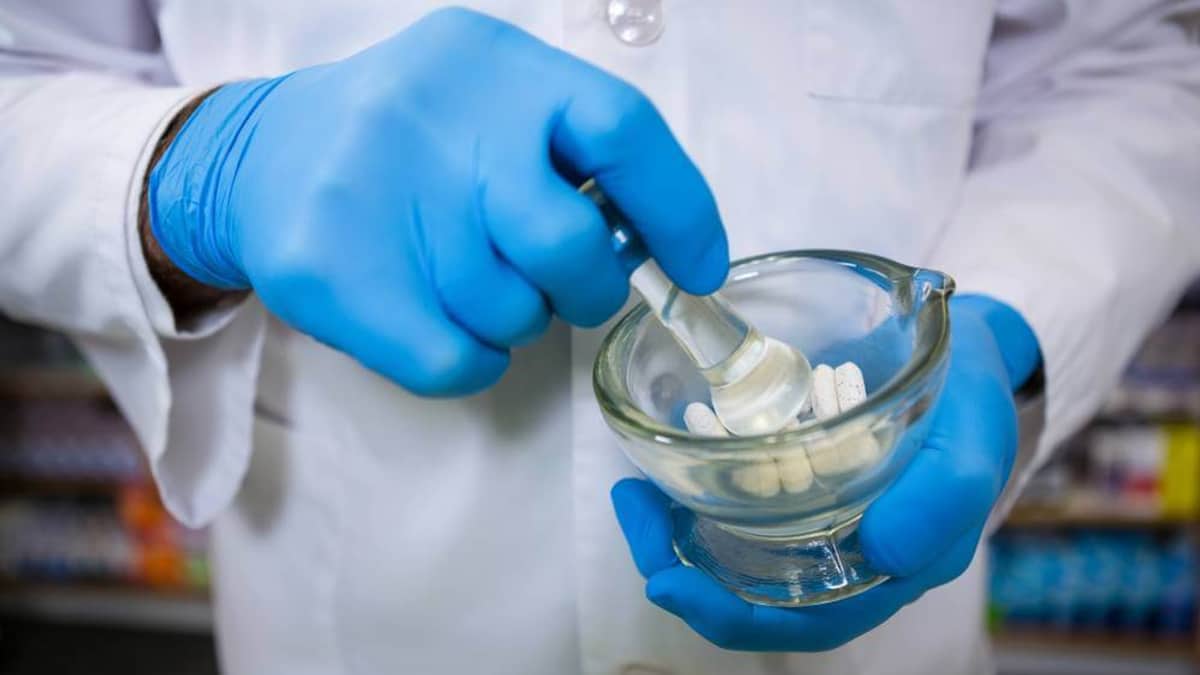 Pharmacist measuring ingredients at a compounding lab workstation