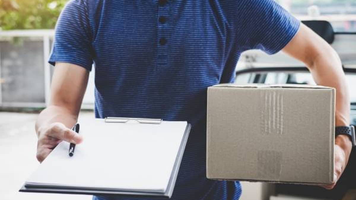Delivery driver handing a prescription package to a customer at their door