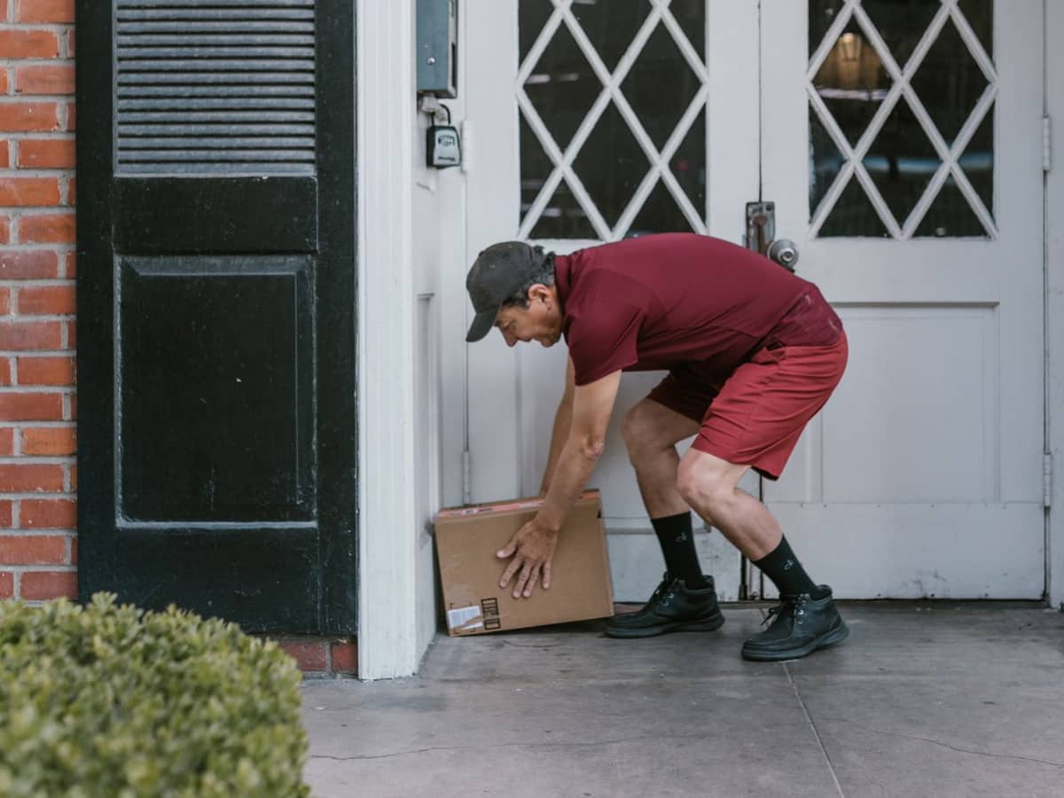 Delivery driver leaving a package at a front door